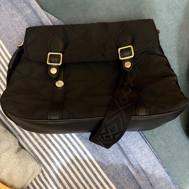 Bolso negro acolchado con detalles dorados