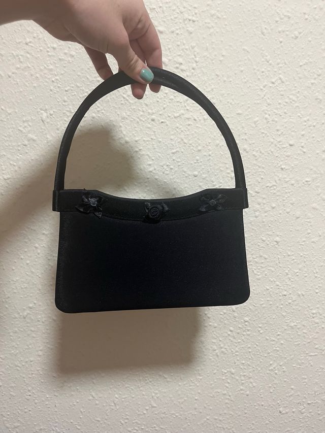 Bolso de mano negro con adornos florales
