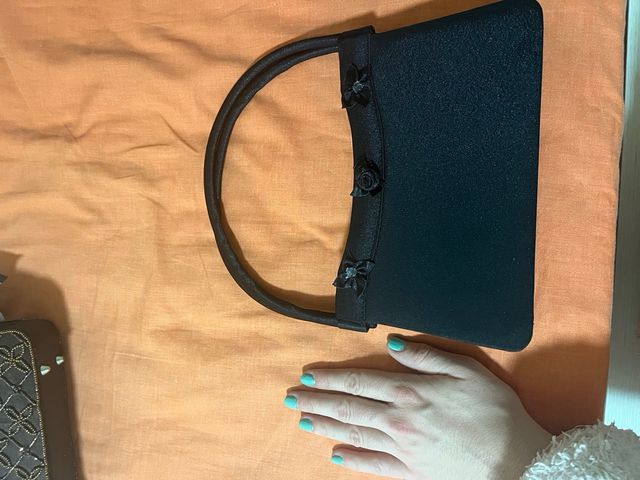 Bolso de mano negro con adornos florales