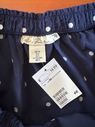 Camisa cuello barco, lunares azul marino y blanco.