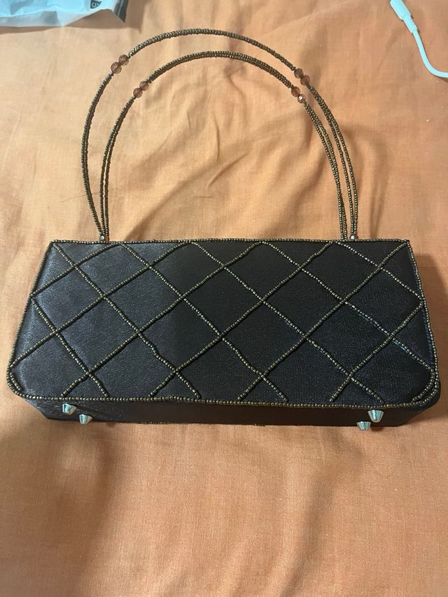 Bolso de mano negro con detalles dorados