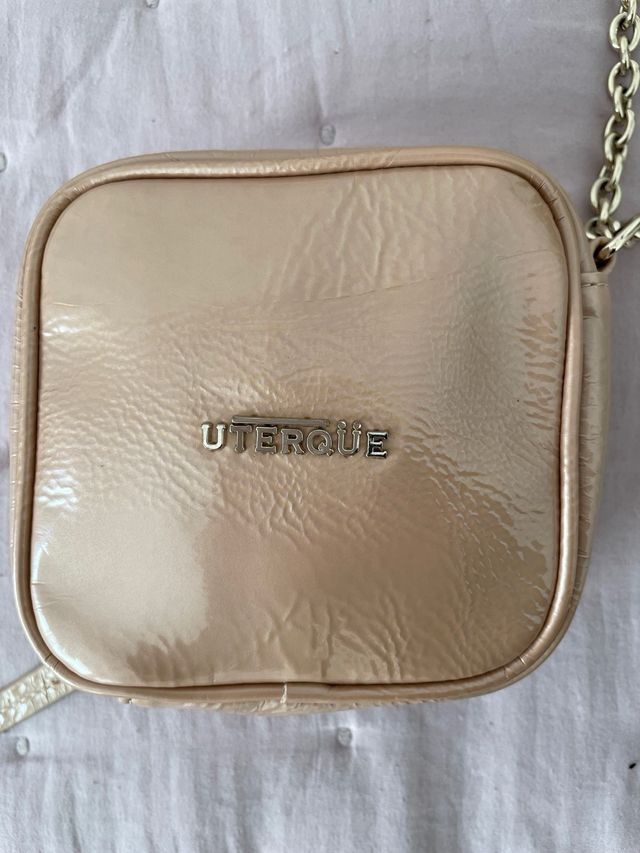 Bolso Uterqüe acharolado beige y dorado