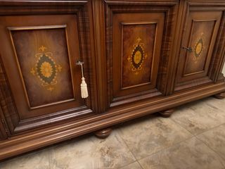 Vitrina de madera raíz con detalles dorados