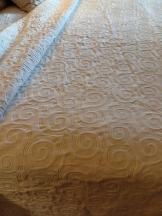 Colcha beige con diseño de espirales