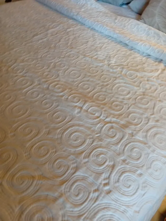 Colcha beige con diseño de espirales