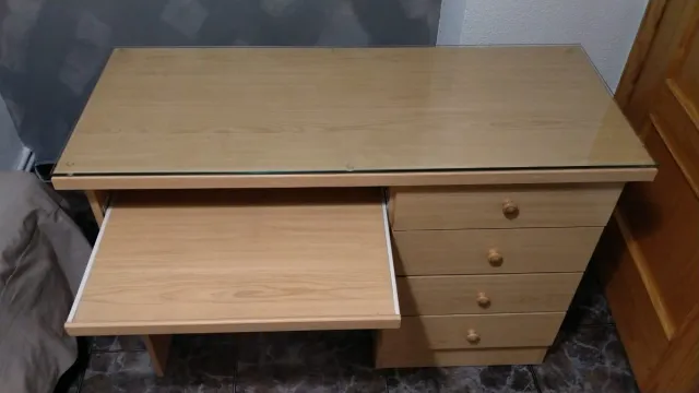 Escritorio de madera con superficie de cristal