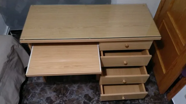 Escritorio de madera con superficie de cristal