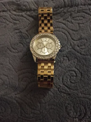 Reloj dorado con pedrería