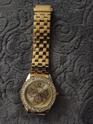 Reloj dorado con pedrería
