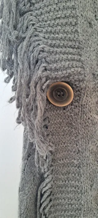 Poncho gris con flecos y broche