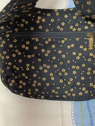 Riñonera Caomka negra con estampado floral