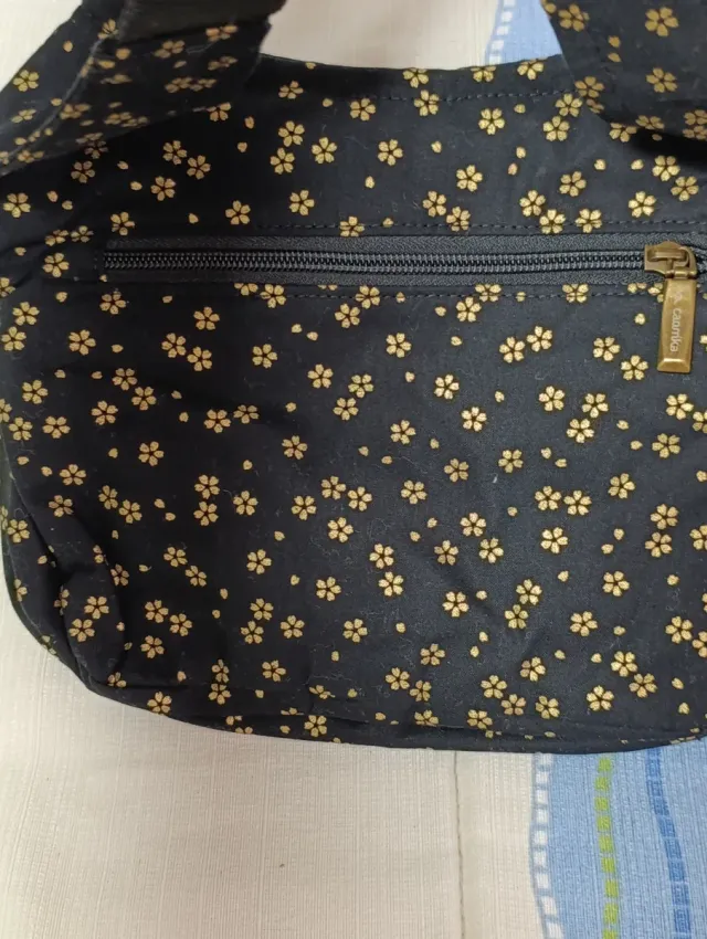 Riñonera Caomka negra con estampado floral