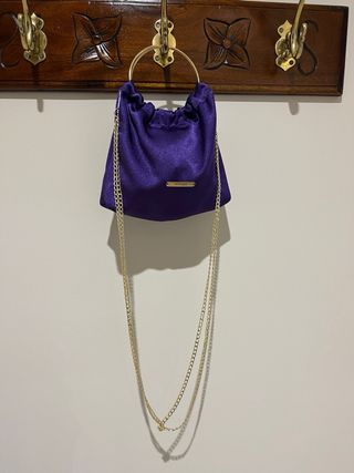 Bolso de mano morado con aro dorado