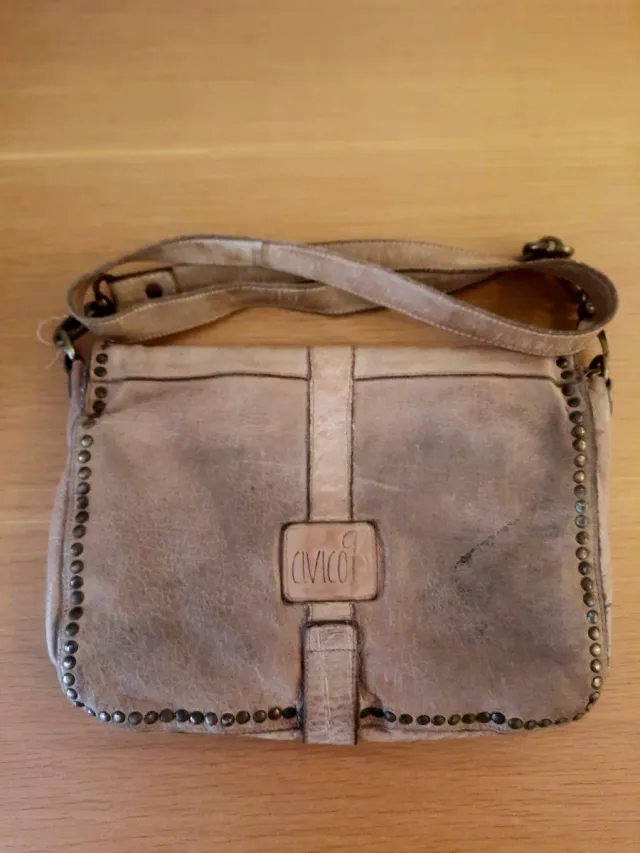 Bolso bandolera piel beige tachuelas.