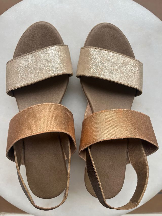 Sandalias planas doradas y marrones