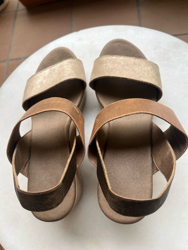 Sandalias planas doradas y marrones