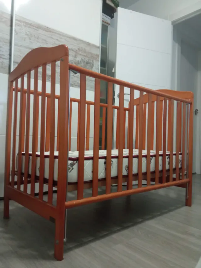 Cuna de madera para bebé con ropa de cama
