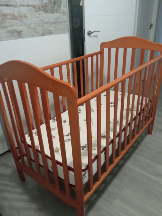 Cuna de madera para bebé con ropa de cama