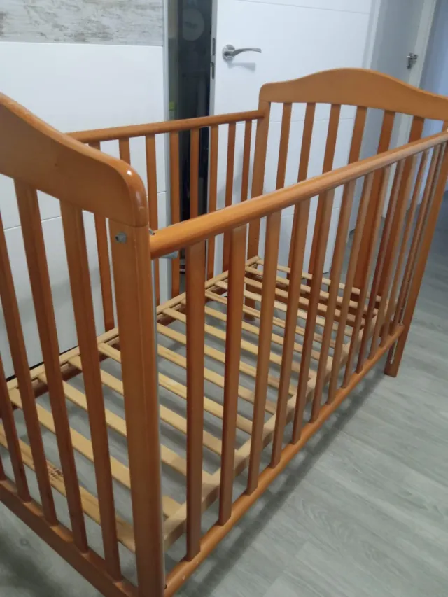Cuna de madera para bebé con ropa de cama