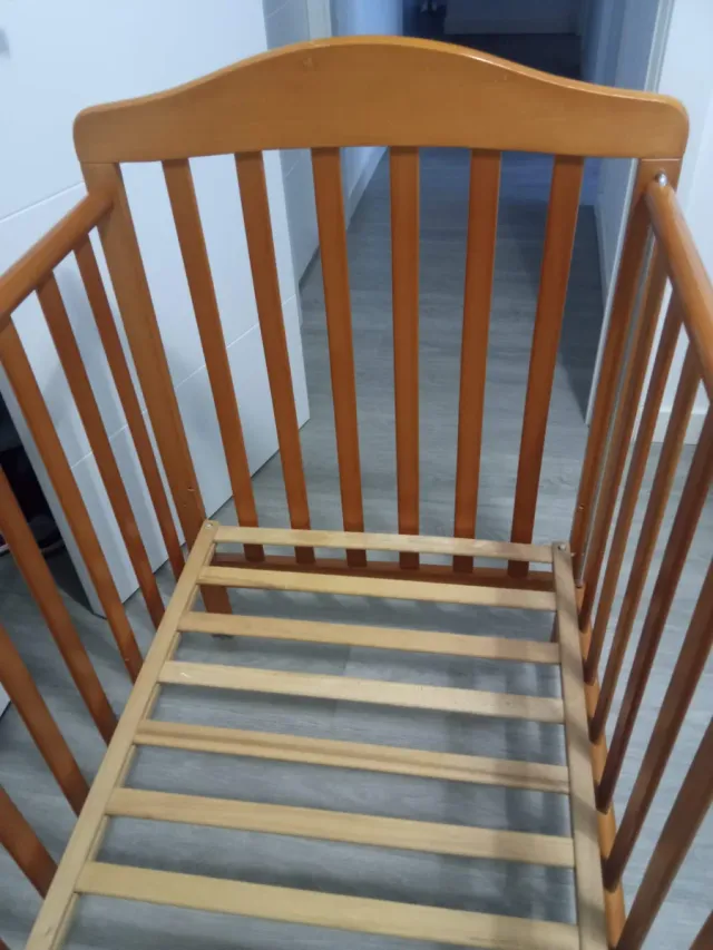 Cuna de madera para bebé con ropa de cama
