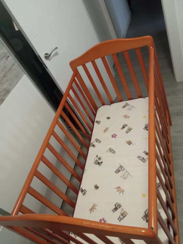 Cuna de madera para bebé con ropa de cama