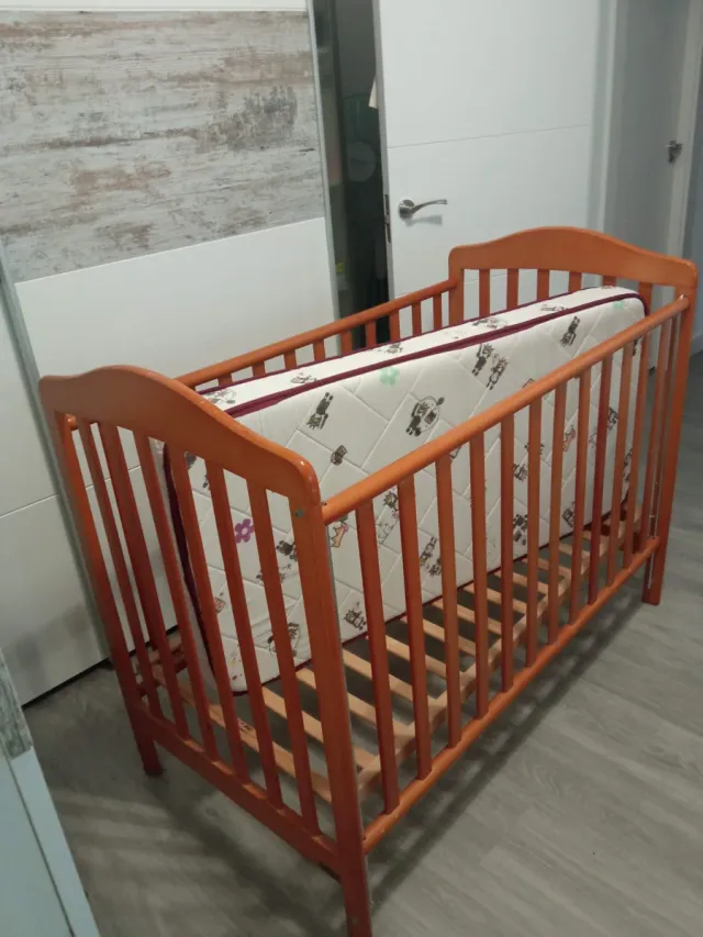 Cuna de madera para bebé con ropa de cama