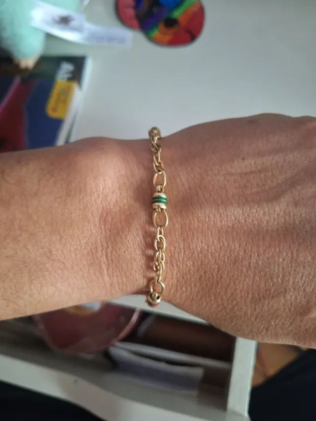 Pulsera de oro con detalles verdes y rojos tambore