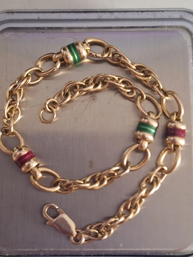 Pulsera de oro con detalles verdes y rojos tambore
