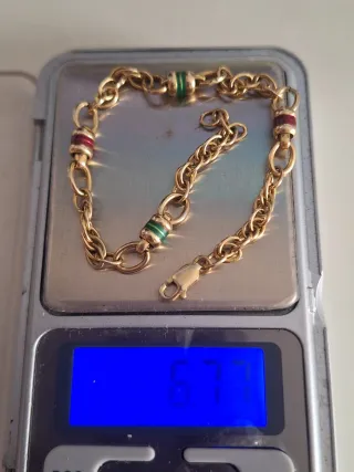 Pulsera de oro con detalles verdes y rojos tambore