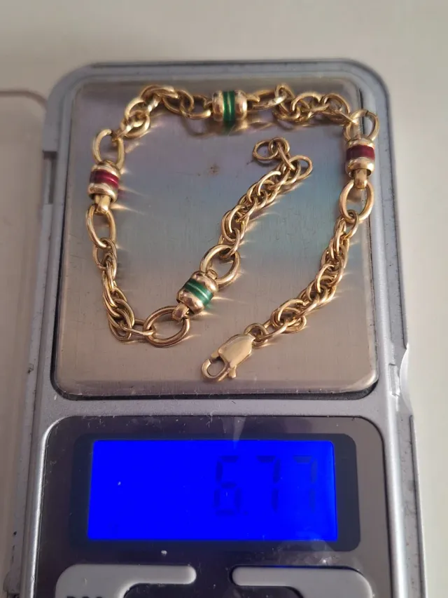 Pulsera de oro con detalles verdes y rojos tambore