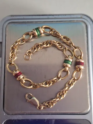 Pulsera de oro con detalles verdes y rojos tambore
