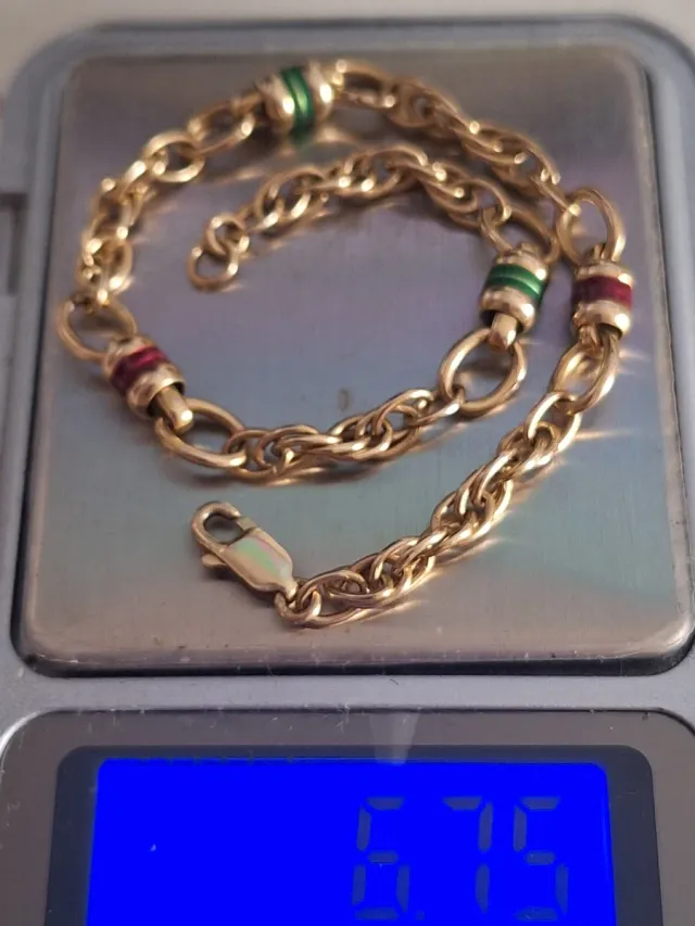 Pulsera de oro con detalles verdes y rojos tambore