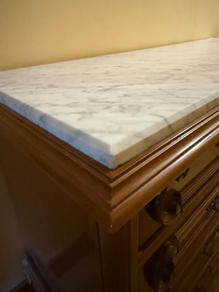 Cómoda de madera con encimera de mármol.