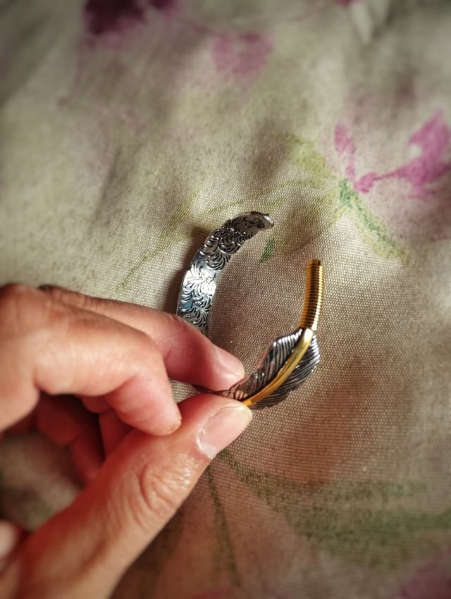 Pulsera brazalete de pluma con línea dorada