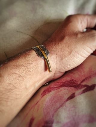 Pulsera brazalete de pluma con línea dorada