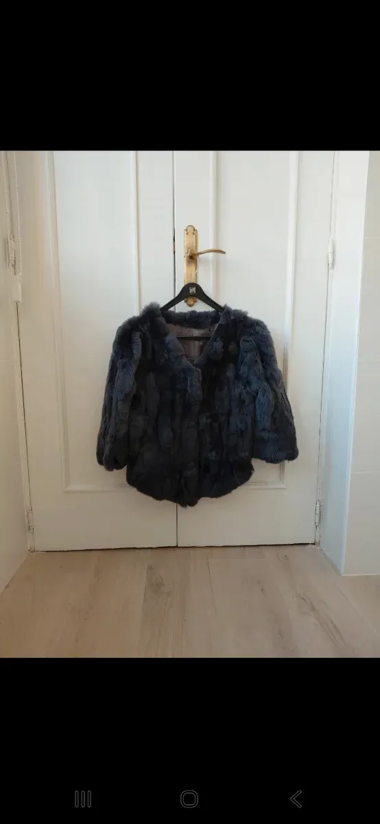 Abrigo de piel corto y gris. Forrado por dentro.