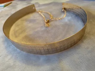 Cinturón metálico dorado con diseño floral