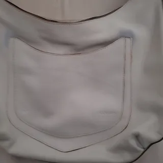 Bolso blanco de piel tiene una pequeña mancha