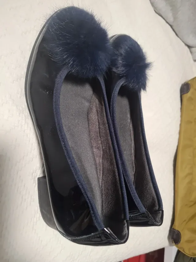 Zapatos negros de charol con pompon azul