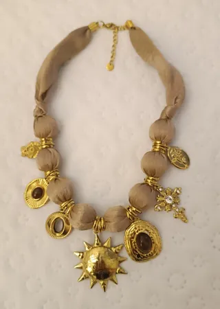 Collar tela beige con cierre y dijes dorados