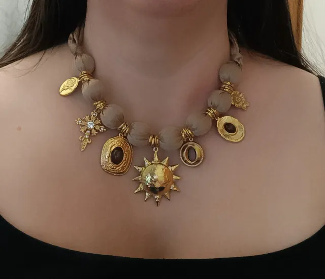 Collar tela beige con cierre y dijes dorados