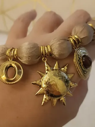 Collar tela beige con cierre y dijes dorados