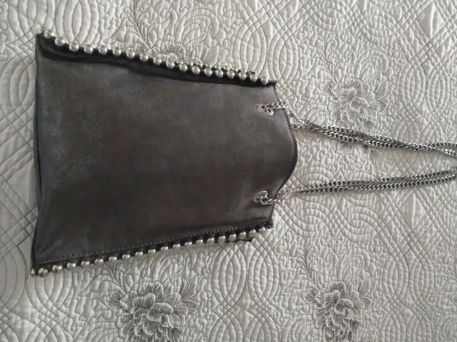 Bolso plateado con cadenas y tachuelas