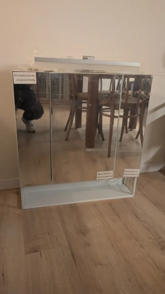 Mueble con espejo de baño blanco.