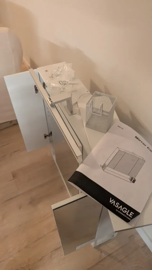 Mueble con espejo de baño blanco.