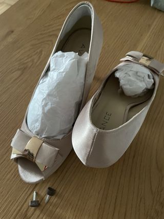 Conjunto Zapatos de tacón y bolso dorado.