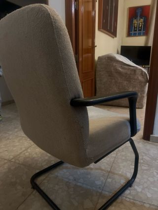 Silla cómoda color beige con base metálica.