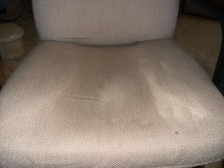 Silla cómoda color beige con base metálica.