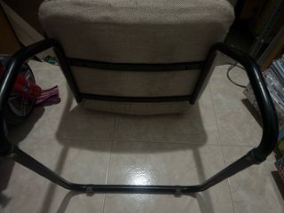 Silla cómoda color beige con base metálica.