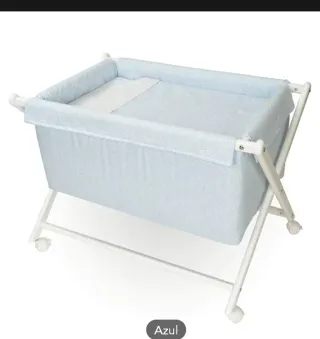 Mini cuna infantil marrón con ruedas.